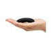 Hand holding a sleek black pebble-shaped clitoral vibrator with a smooth silicone finish.
