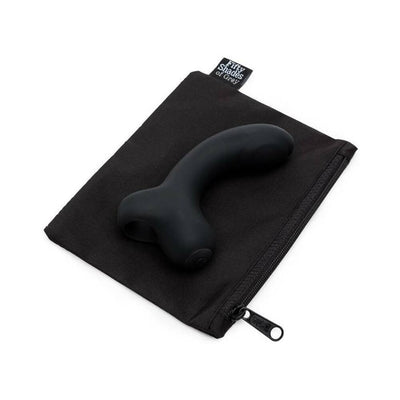 Black curved silicone G-spot vibrator resting on a black zippered storage pouch with Fifty Shades of Grey label.