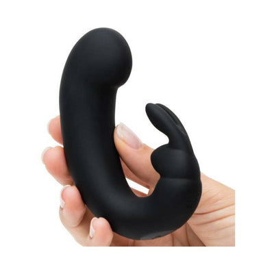 Hand holding a sleek black silicone G-spot rabbit vibrator with curved tip and flickering ears.