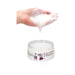 Hand holding white gel above an open jar of Fist It Anal Relaxer lubricant cream.