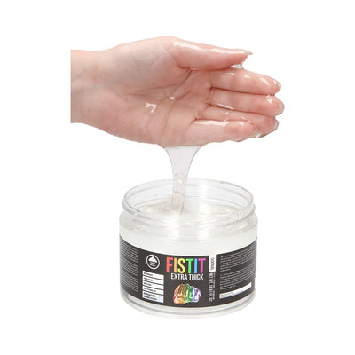 Hand holding clear, thick water-based lubricant gel above an open jar of Fist It Extra Thick Rainbow 16 oz.