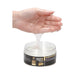 Hand holding clear gel lubricant dripping into an open jar of Fist It water-based lubricant.