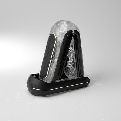 Black and translucent Flip Zero Vibration Stroker with textured inner sleeve and water droplets on a white surface.