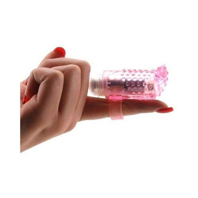 Pink textured vibrating finger sleeve worn on index finger with red nail polish on hand against white background