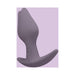 Purple silicone Fun Factory Bootie Fem plug with asymmetrical base on a lavender background