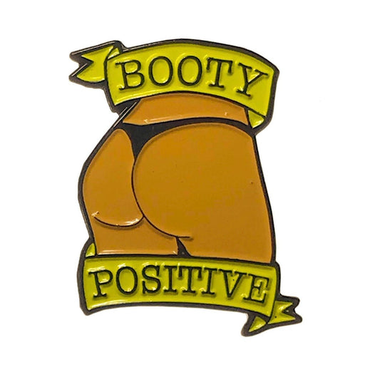 Caramel enamel pin featuring a stylized booty with black thong and yellow banners reading "Booty Positive"