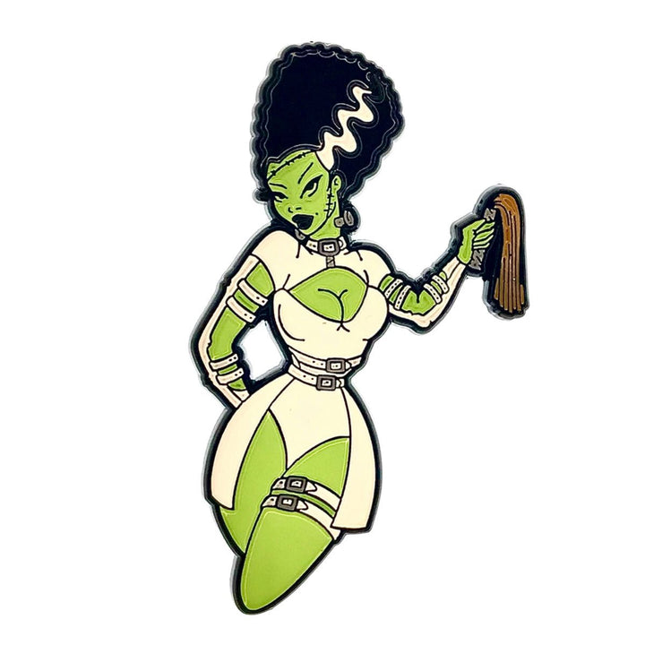 Enamel pin of a stylized green Bride of Frankenstein character in a white outfit holding a whip accessory.