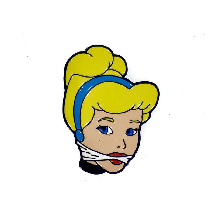 Enamel pin featuring a stylized blonde woman with blue headband and white gag detail, vibrant colors on white background.