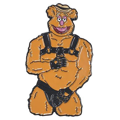 Enamel pin of a muscular bear character wearing black leather harness and gloves, playful and bold accessory design.