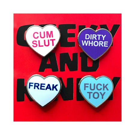 Set of four colorful heart-shaped enamel pins with bold playful phrases on a red background.