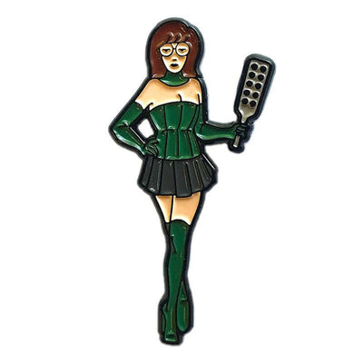 Enamel pin of a woman in green corset, gloves, boots, and black skirt holding a paddle with holes.