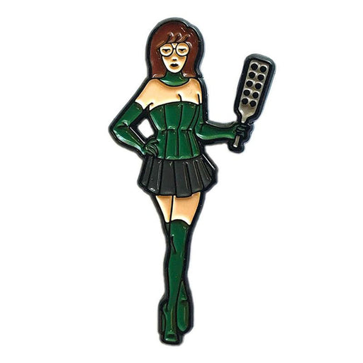 Enamel pin of a woman in green corset, gloves, boots, and black skirt holding a paddle with holes.