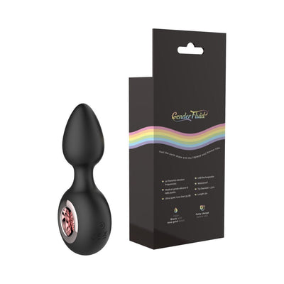 Black silicone Gender Fluid Tremor Ring Plug with rose gold detail next to its black packaging with rainbow design.