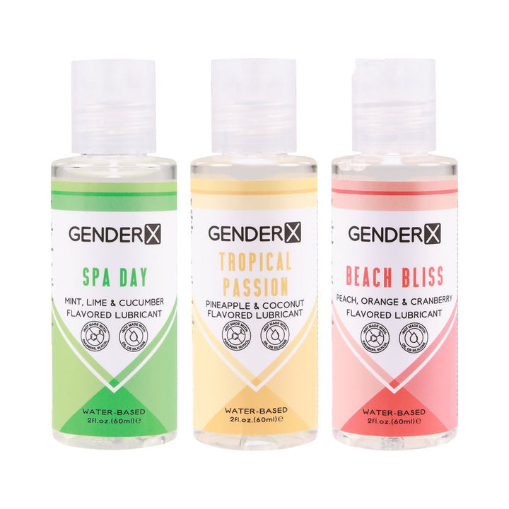 Three 2 oz Gender X water-based flavored lubricants in Spa Day, Tropical Passion, and Beach Bliss scents with colorful labels.