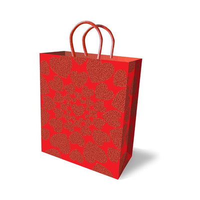 Red holiday gift bag decorated with glittery red hearts and red rope handles on a white background.