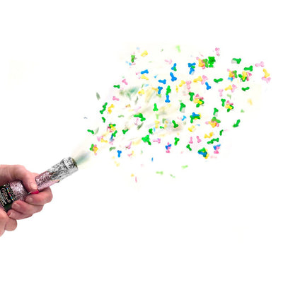 Hand holding a pink glittery confetti popper releasing colorful adult-themed confetti on a white background.