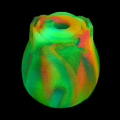 Glow-in-the-dark silicone clit stimulator shaped like a vibrant rainbow rose with a central suction opening.