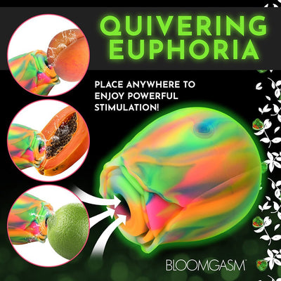 Rainbow-colored glow-in-the-dark rose clit stimulator with suction feature shown alongside fruit for size and stimulation demonstration.