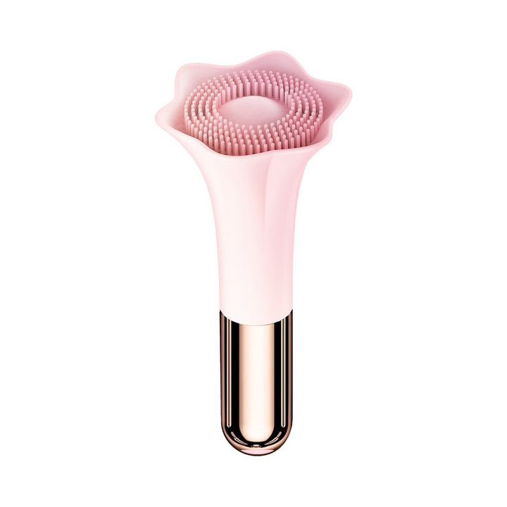 Pink silicone massager shaped like a flower with soft bristles and a metallic rose gold handle.