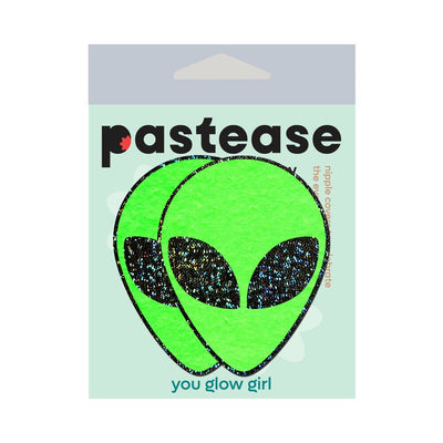 Green glitter alien face pasties with black sparkling eyes on Pastease branded packaging.