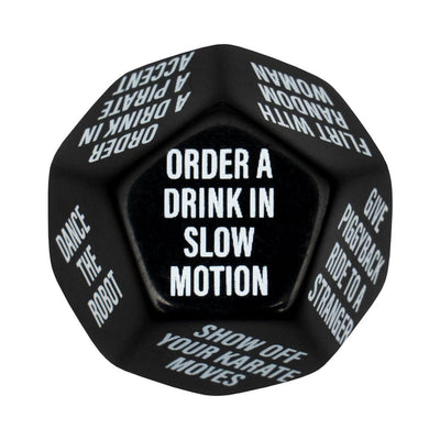 Black 12-sided dice showing party dares like order a drink in slow motion and dance the robot for bachelor party game.