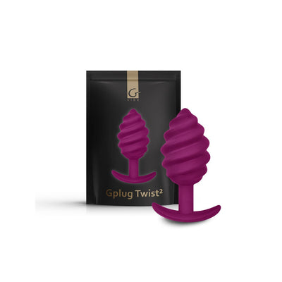 Gvibe Gplug Twist 2 in sweet raspberry with a ribbed, twisted design and ergonomic base next to its black packaging.