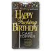 Gold glitter Happy Fucking Birthday cake topper on black packaging with colorful confetti design at the top.