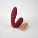 Wine red Hercules C-shape vibrating plug with a rose gold remote control on a white background