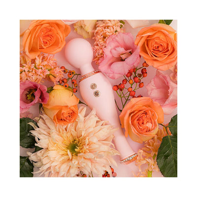 Pink silicone body wand with decorative accents surrounded by orange and pink flowers on a soft background.