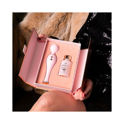 Open gift box showing a pink silicone body wand and a bottle of HighOnLove sensual massage oil on a soft pink insert.