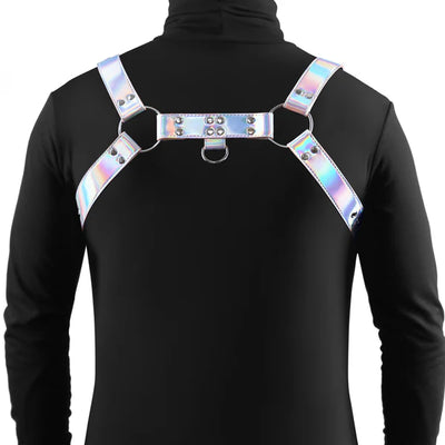 Back view of a person wearing a rainbow holographic adjustable chest harness with silver hardware over a black long-sleeve top.