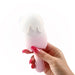 Hand holding a pink and white cream pop-shaped Honey Play Box Bite Me stimulator with a smooth silicone finish.