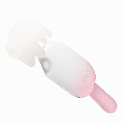 White and pink Honey Play Box Bite Me cream pop stimulator with a removable soft silicone cover on a white background.