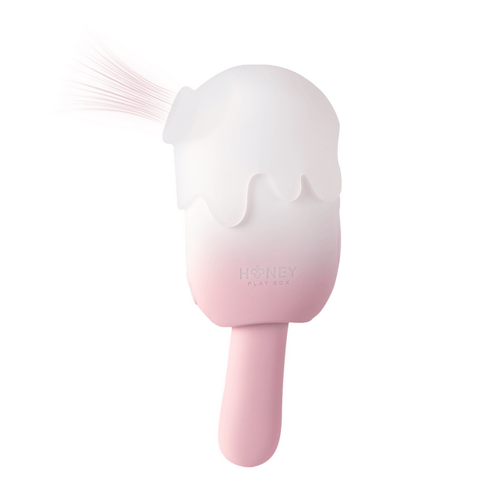 Pink and white cream pop-shaped stimulator with soft silicone tip and Honey Play Box logo on handle.