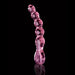 Pink glass beaded massager with curved, textured design and heart-shaped handle on black background.