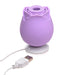 Purple rose-shaped silicone clitoral suction stimulator with USB charging cable on white background.