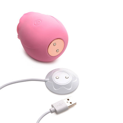Pink rose-shaped silicone clitoral stimulator with magnetic USB charging cable on white background.