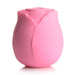 Pink rose-shaped silicone clitoral suction stimulator with smooth petals and compact design.