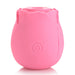 Pink silicone rose-shaped clitoral suction stimulator with a single button on the front, designed for discreet pleasure.