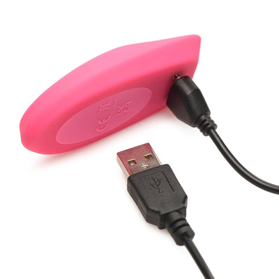 Pink silicone Inmi Spin N Grind charging with black USB cable on white background.
