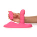 Pink silicone hands-free grinding pad with rotating shaft and remote control held by hand on white background.