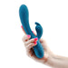 Hand holding a blue silicone INYA Luv Bunny vibrator with dual stimulation design and curved shape.