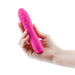 Hand holding a compact pink textured silicone vibrator with a rounded tip and raised bubble design.