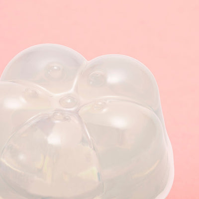 Close-up of a translucent, flower-shaped gel moisturizer on a soft pink background.