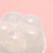 Close-up of a translucent, flower-shaped gel moisturizer on a soft pink background.