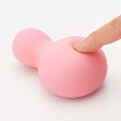 Soft pink snowman-shaped silicone personal massager with finger pressing to show its supple texture.