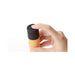Hand holding and pressing the power button on a compact orange Iroha Zen mini vibrator with a black top.