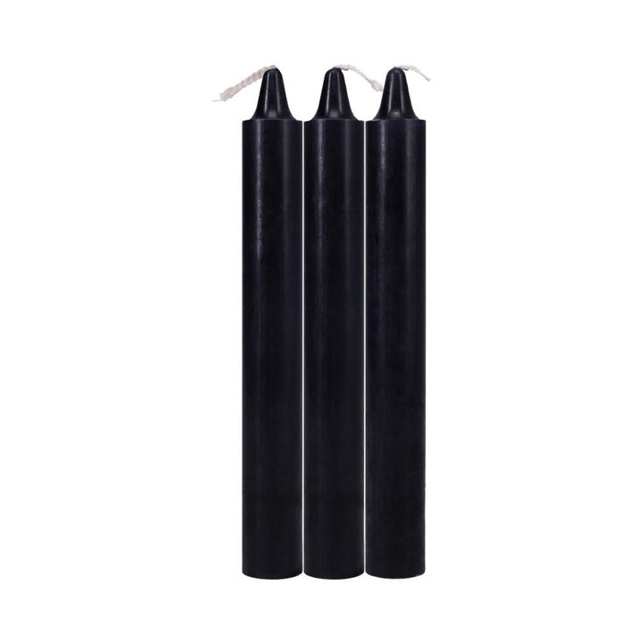 Three tall black Japanese drip candles with white wicks, arranged side by side on a white background.