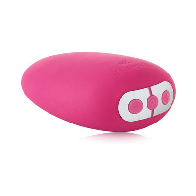 Pink ergonomic Je Joue Mimi clitoral vibrator with three control buttons on white panel against white background.
