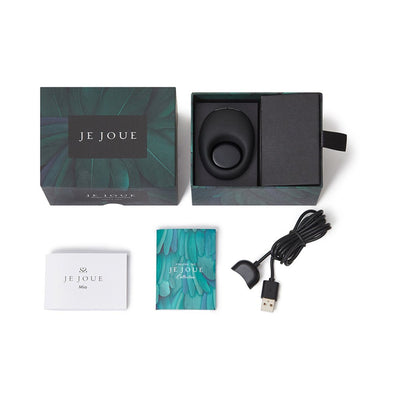 Je Joue Mio black silicone cock ring with packaging, USB charging cable, and instruction booklets on white background.